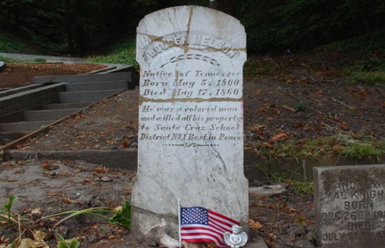 Photograph of a white granite tombstone, with carved text on it, in Evergreen Cemetery.